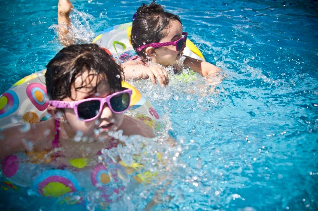 young kids in pool with floaters
