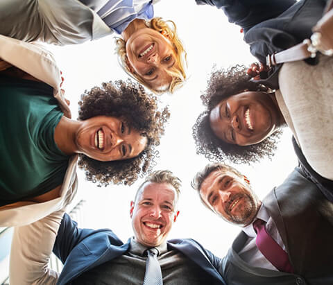 Friends in huddles smiling at camera