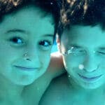 Two kids swimming underwater
