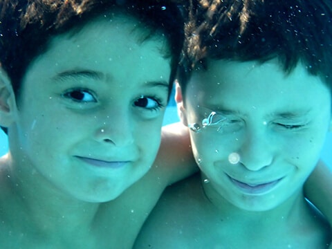 Two kids swimming underwater