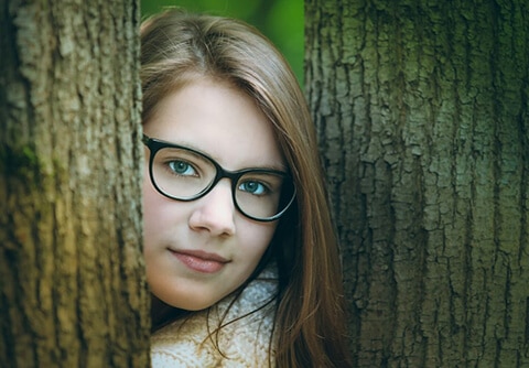 Woman looking between trees