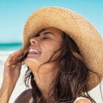 Happy woman on beach with hat