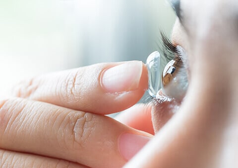 Woman putting on contact lenses