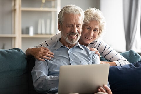 Older Couple Reading Laptop