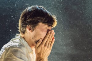 person sneezing due to seasonal allergies