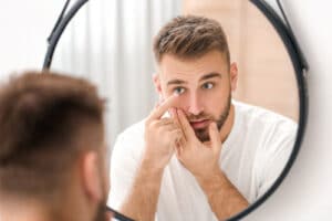 man putting contacts in