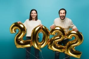 two people holding up 2022 balloons 