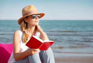 woman reading book on beach 