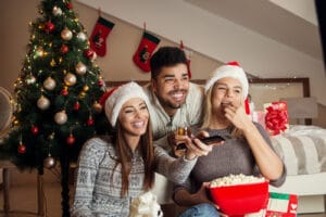 three people watching tv eating popcor during the holidays