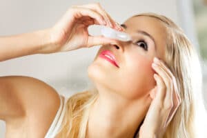 woman putting eye drops in 