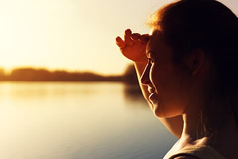 Woman looking into distance at sunset